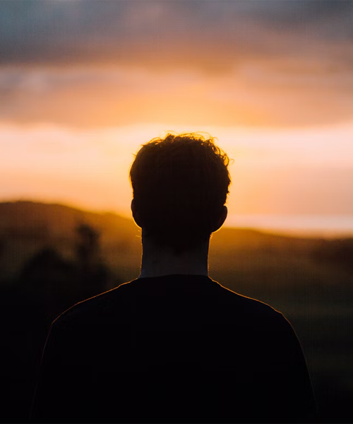 Silhuett av en man som möter en solnedgång